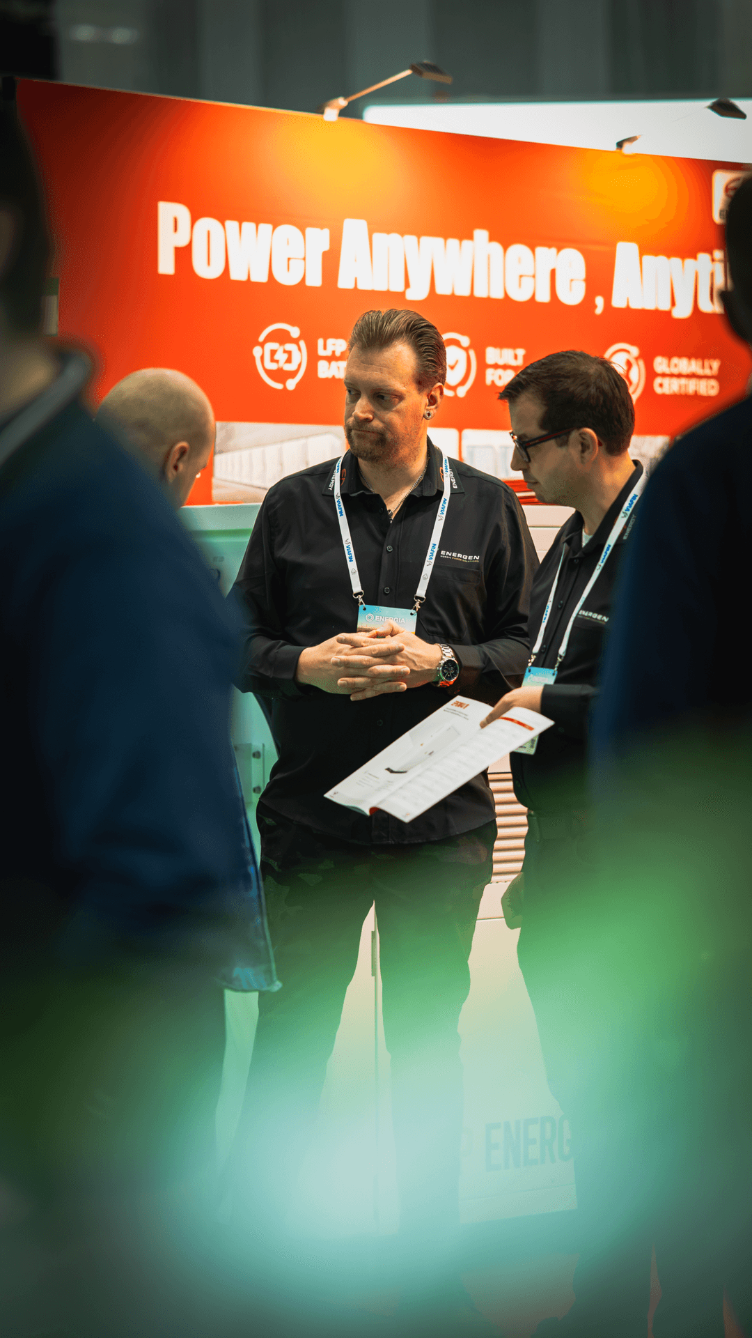 Visitors talking in front of a red exhibition wall at Energia 2026 in Tampere