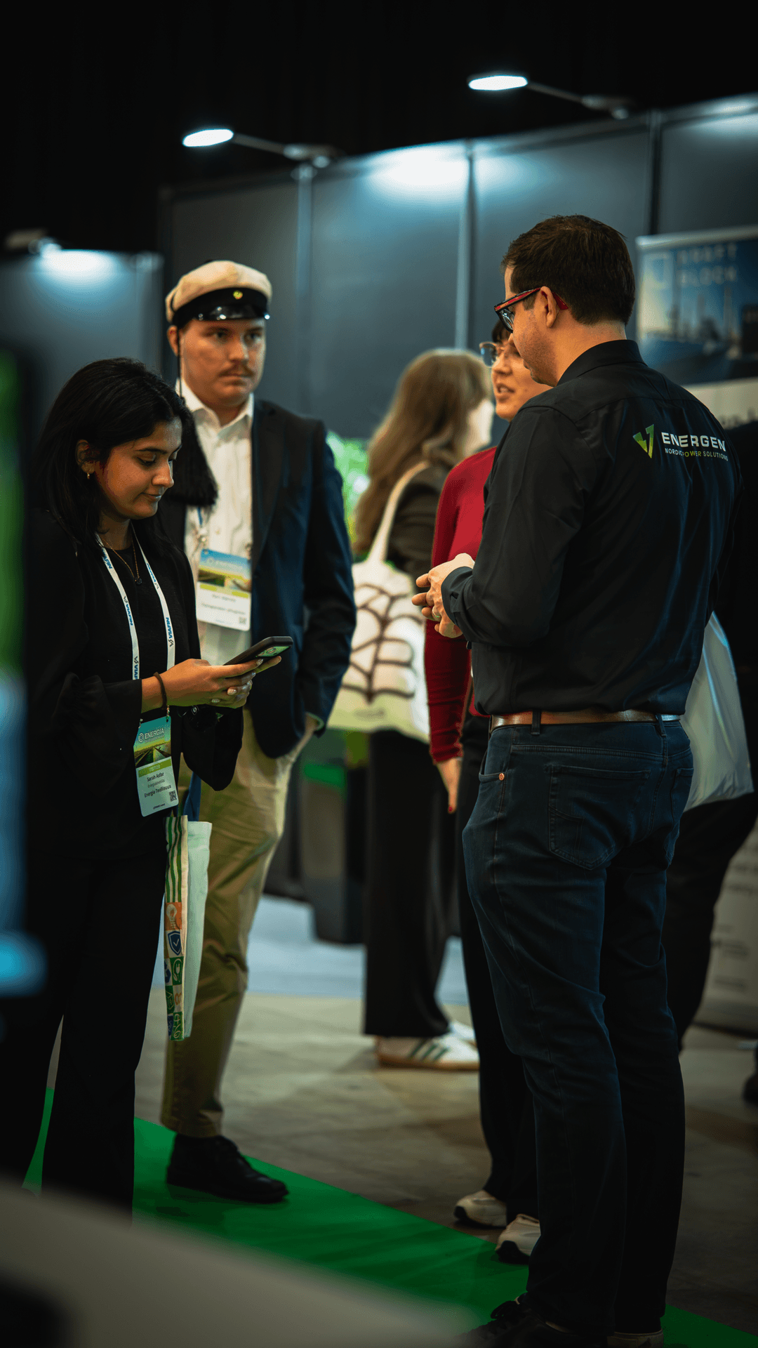 A group talking with a person wearing an Energen Nordic jacket at an exhibition stand