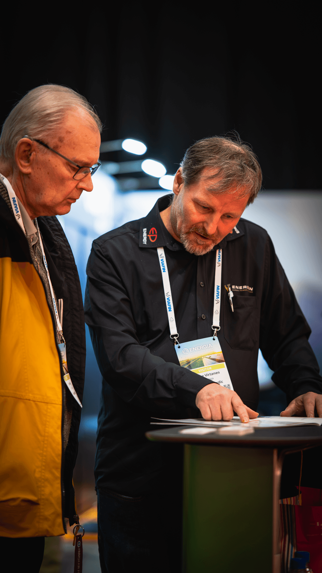 Two visitors reviewing material at a table at the Energia 2026 trade fair